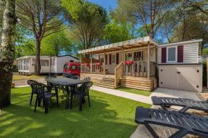 a cabin with a table and chairs in a yard at Mobil-home Badji in Gastes