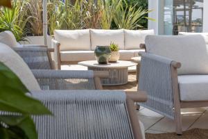 a patio with chairs and a table and a couch at Alda Seaview Hotel in Cervia