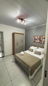 a bedroom with a large bed and a ceiling at Apartamento em Lauro de Freitas in Lauro de Freitas