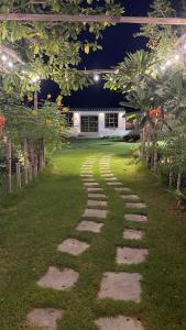 a walkway in a yard at night with lights at Oasis Rest ae in Madīnat an Nahḑah