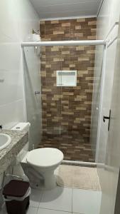 a bathroom with a toilet and a glass shower at Apartamento em Lauro de Freitas in Lauro de Freitas +20 photos