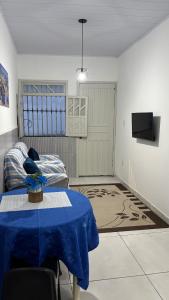 a living room with a table and a tv at Apartamento em Lauro de Freitas in Lauro de Freitas