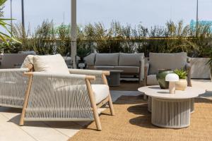 a patio with wicker chairs and a table at Alda Seaview Hotel in Cervia