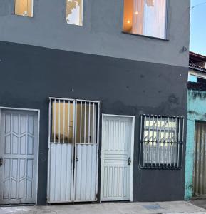 two white doors on the side of a building at Apartamento em Lauro de Freitas in Lauro de Freitas