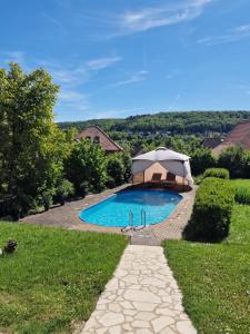a swimming pool with an umbrella in a yard at Villa Kayser in Freyburg