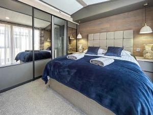 a bedroom with a large bed with a blue blanket at Marina Escape One in Peterhead