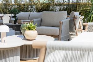 a patio with a couch and tables and chairs at Alda Seaview Hotel in Cervia