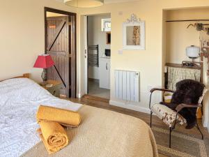 a bedroom with a bed and a chair and a table at Rose Chalet in Framlingham
