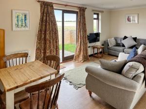a living room with a table and a couch at Rose Chalet in Framlingham