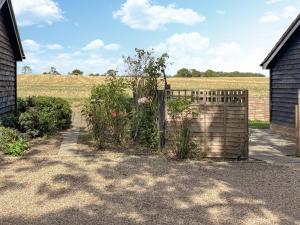 a fence with a gate in front of a field at Rose Chalet in Framlingham