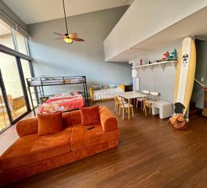 a living room with a couch and a bed and a surfboard at Duplex Close to HPU Waikiki Pool Terrace Laundry One and Half Bath for 15person in Honolulu