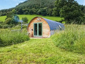 a small wooden cabin in a field of grass at Barcud Coch - Uk44539 in Hirnant +25 photos