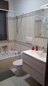 a bathroom with a toilet and a tub and a sink at NUOVO Alloggio Giardino di Rosy tra Roma EUR e il Mare di Ostia in Vitinia +16 photos