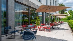 a patio with tables and chairs and an umbrella at Holiday Inn Express - Wiesbaden by IHG in Wiesbaden