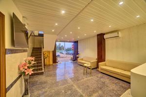 a lobby with couches and a staircase in a building at RedKEY Inn Transit Hotel Bangalore Airport in Bangalore