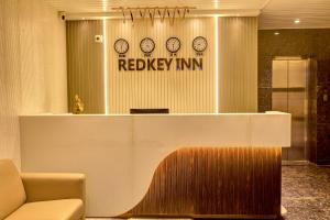 a lobby with a reception desk with clocks on the wall at RedKEY Inn Transit Hotel Bangalore Airport in Bangalore