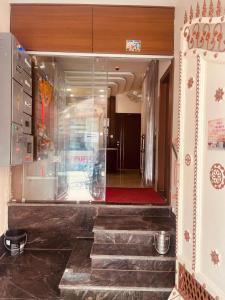 a room with a glass wall with stairs and a red rug at Maa Prabha Courtyard in Varanasi