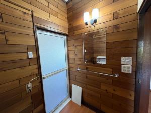 a bathroom with wooden walls and a glass door at 民泊ごとう in Kitakami +24 photos
