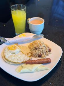 a plate of breakfast food with eggs sausage and bread at Hotel Casa Florida 70 Medellin in Medellín +17 photos