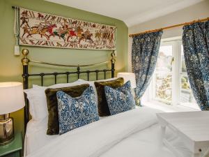 a bedroom with a bed with blue and white pillows at Keepers Cottage - Ukc3950 in Puncknowle