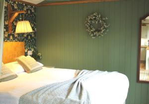 a bedroom with a bed with a wreath on the wall at Chycara House in Truro