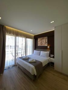 a bedroom with a large bed and a large window at O!live Fully Equipped Apartments with Unique Design in Athens +177 photos