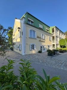 a large white building with a green roof at Romantik Hotel Das Lindner in Bad Aibling