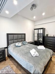 a bedroom with a bed with two towels on it at PREMIUM Apartament & Wellness with jacuzzi, sauna , gym , pool in Bucharest