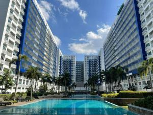 a swimming pool in front of two tall buildings at Sea Residences at Jireh Psalm374 in Pasay
