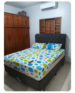 a bedroom with a bed with a blue and yellow comforter at Casa gonçalves in Trindade