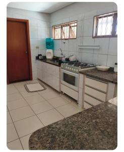a kitchen with a stove and a counter top at Casa gonçalves in Trindade
