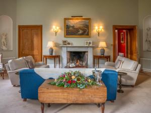a living room with a blue couch and a fireplace at Dalnaglar Castle - Uk7072 in Cray