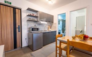 a kitchen with a stainless steel refrigerator and a table at Silver Sunset 26 in Veliko Gradište