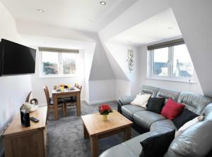 a living room with a couch and a table at Austens Apartments in Torquay