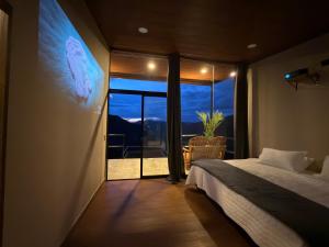 a bedroom with a bed and a large window at Payara Experience in La Vega +57 photos