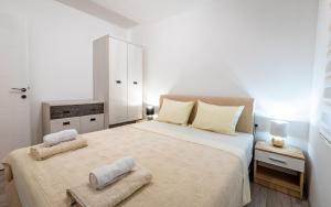a bedroom with a large bed with two towels on it at Silver Sunset 26 in Veliko Gradište
