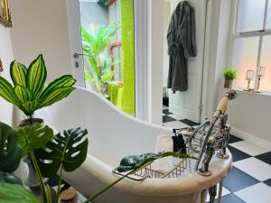 a bath tub in a bathroom with plants at Goblin's Creek in St. Helena Bay