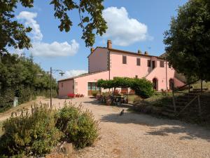 a pink house with a cat sitting in front of it at Agriturismo Il Giovannello in Roccastrada