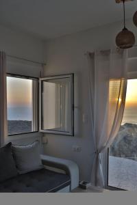 a living room with a couch and two windows at Eagle's Nest Kythnos in Flampouria