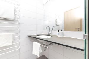 a white bathroom with a sink and a mirror at first Apart in Erlangen +28 photos