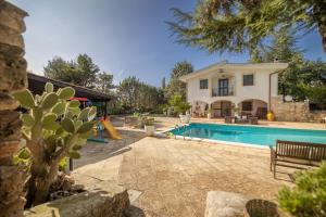 a villa with a swimming pool in front of a house at Villa Corallo in Villa Castelli