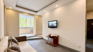 a living room with a couch and a tv on the wall at Calm Central Apartment in Kharkiv