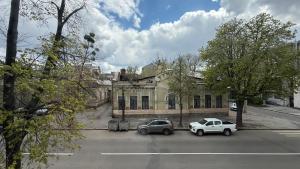 two cars parked in front of an old building at Calm Central Apartment in Kharkiv