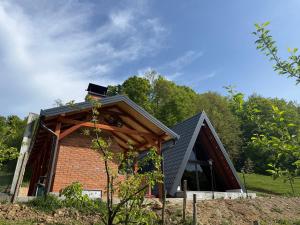 a house with a black roof and a brick at Vila Mirra in Teslić
