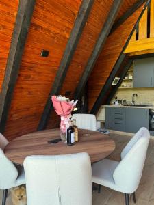 a dining room with a wooden table and white chairs at Vila Mirra in Teslić