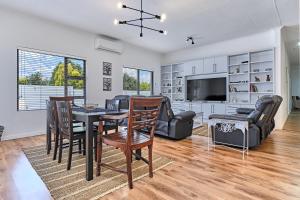 a dining room and living room with a table and chairs at 2 Kiaat Suites in Klerksdorp