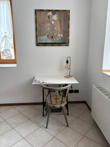 a desk with a chair and a painting on a wall at Appartamento Nicoletta in Portolo