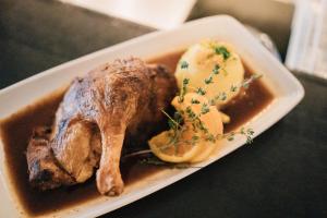 a plate of food with meat and potatoes on a table at Klostermaier Hotel & Restaurant in Icking