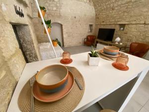ein Tisch mit Schüsseln und Tellern darauf in der Unterkunft Amber's House in Casamassima