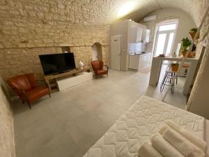 ein großes Wohnzimmer mit Fernseher und Küche in der Unterkunft Amber's House in Casamassima